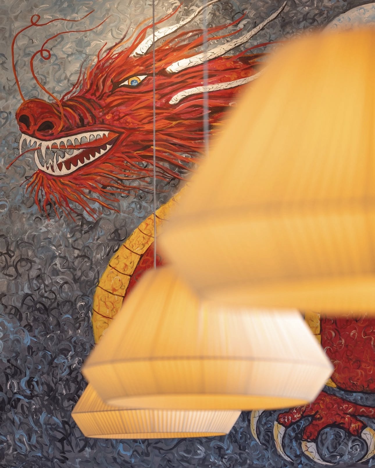 Red dragon mural behind glowing pendant lamps